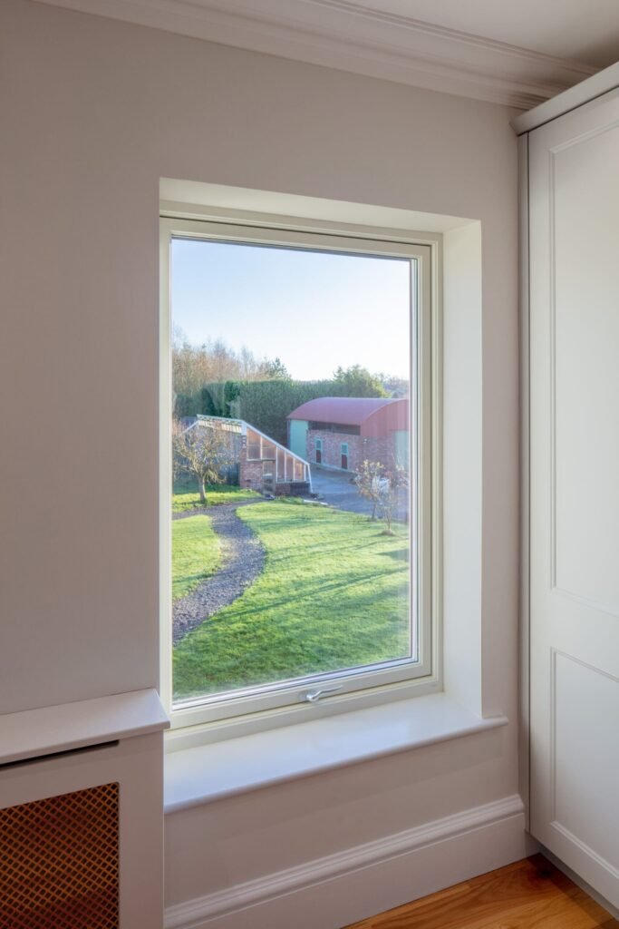 Window overlooking a garden path and barn.