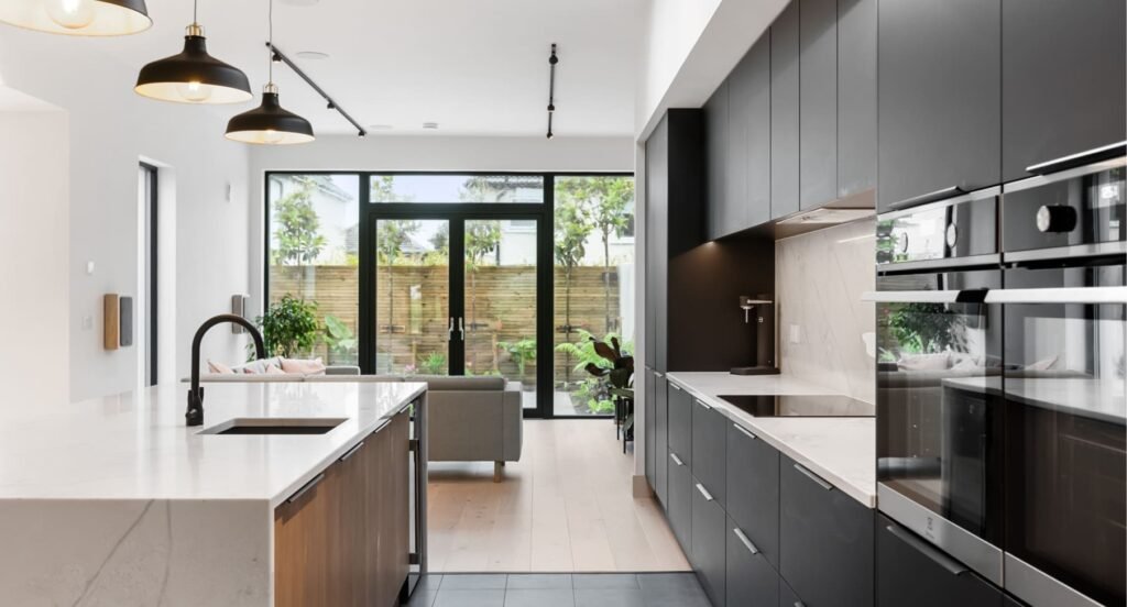 A modern black & marble kitchen with living area.