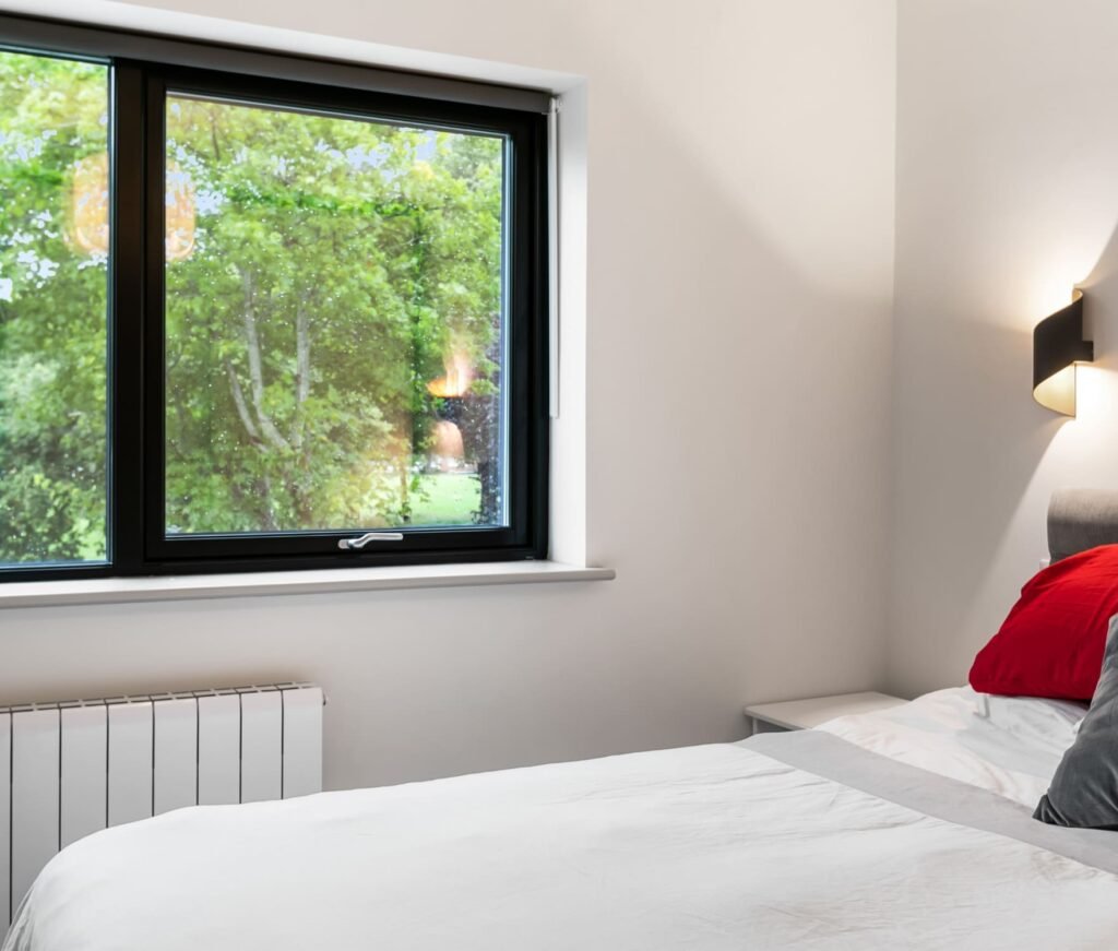 A white bedroom with red pillow.