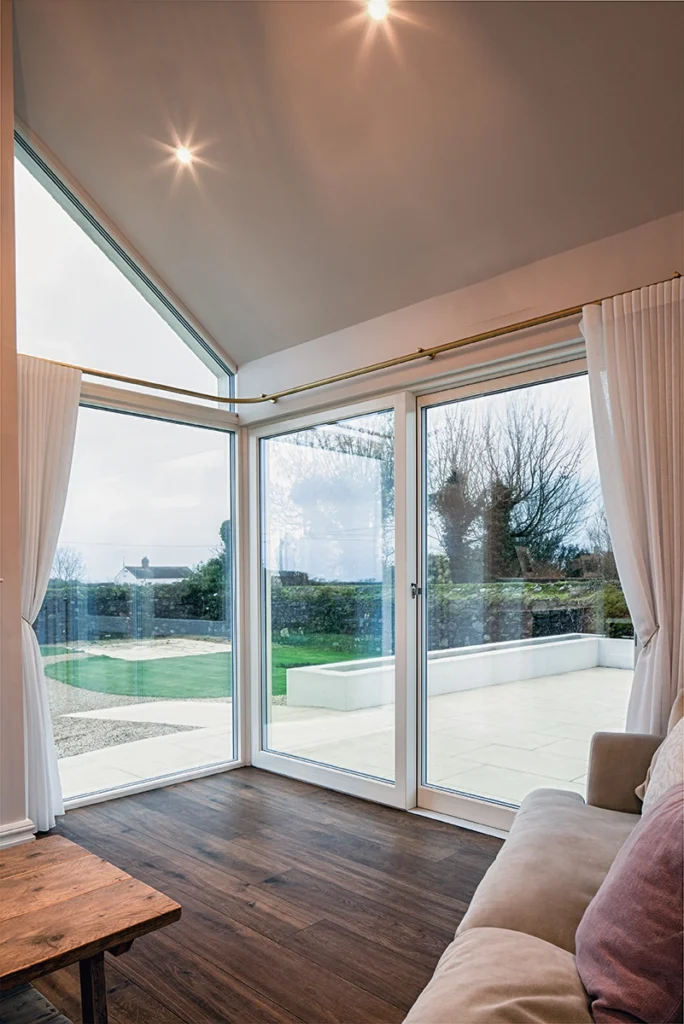 A modern living room with a window with a white curtain.