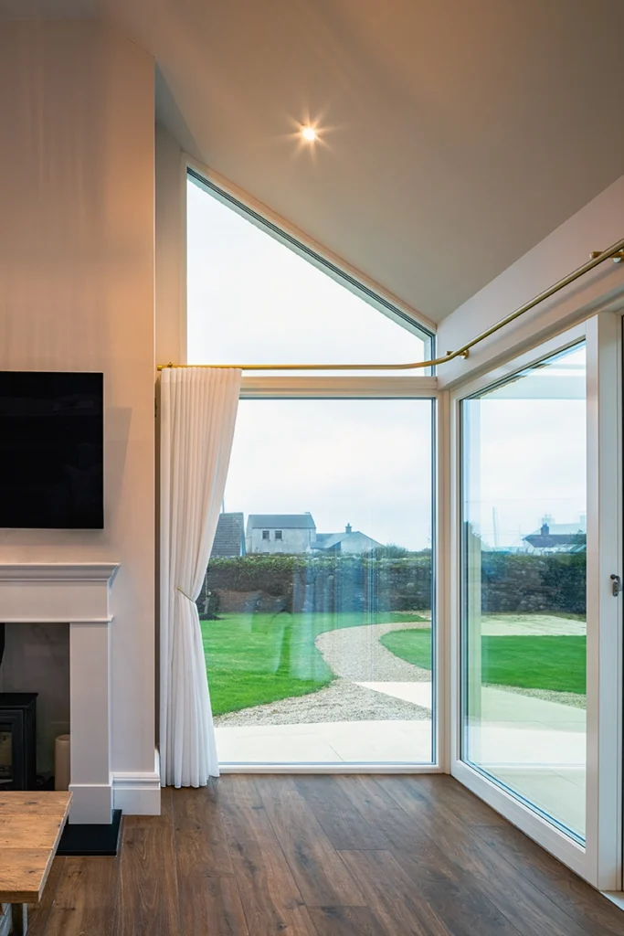 A modern living room with a window with a white curtain.