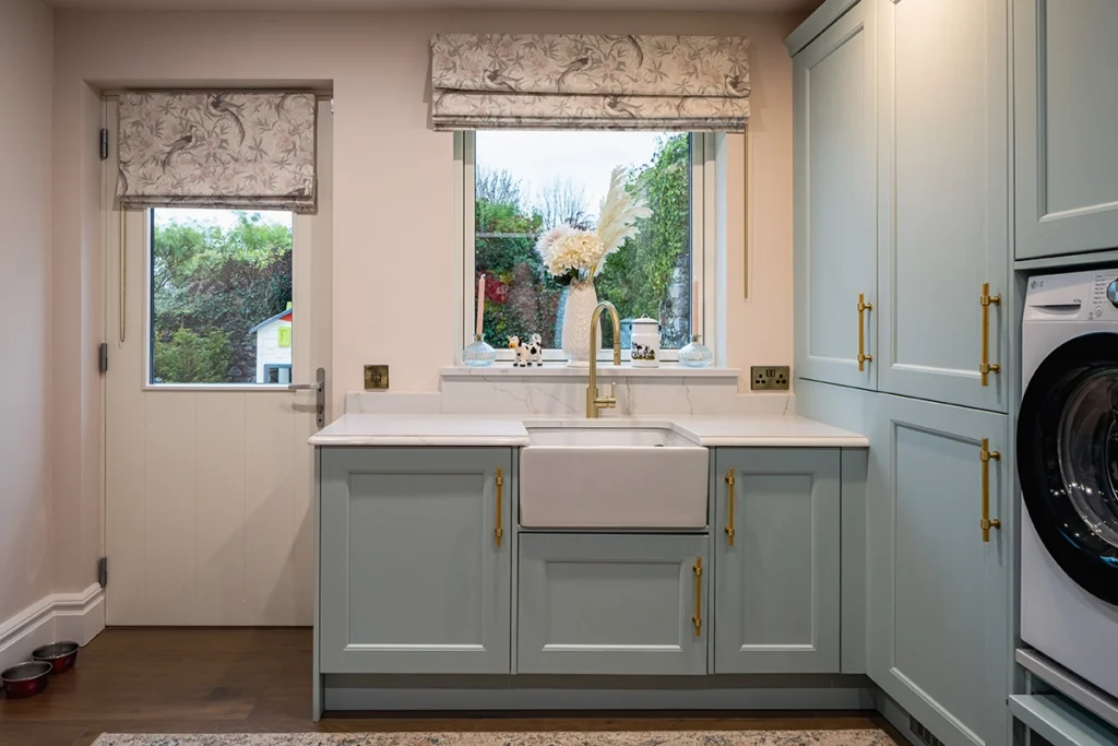 A white kitchen room with blinds rolled up.