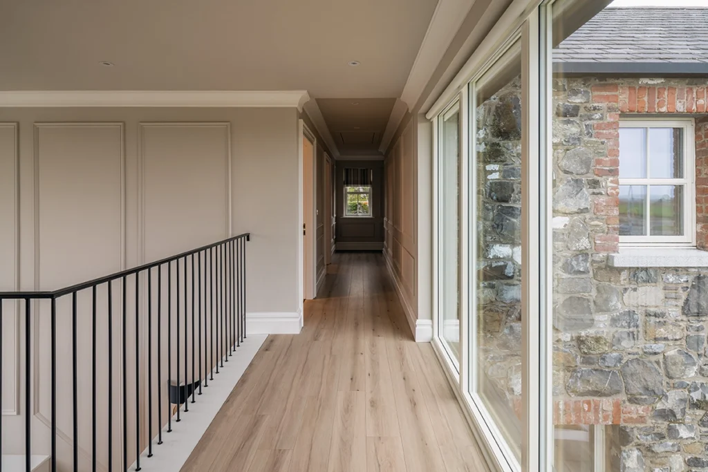 A long hallway with black railing on the left side.