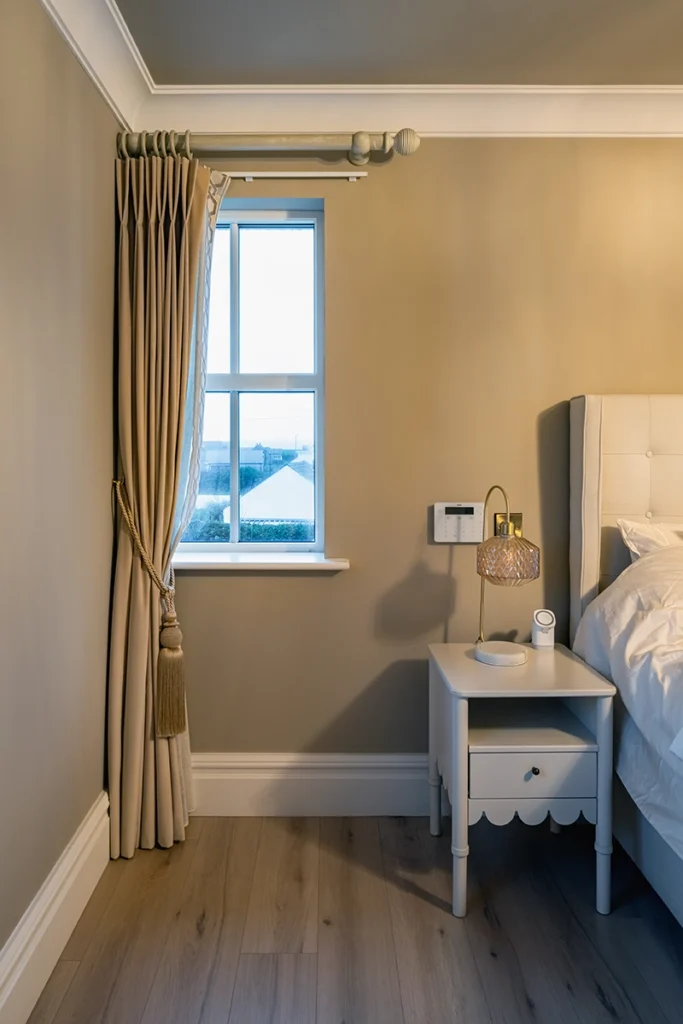 A modern bedroom with a small window and a curtain.