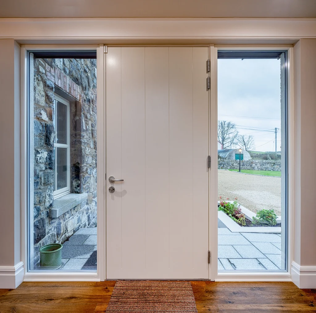 A white modern door with vertical windows beside it.