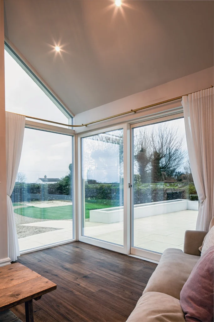 A modern livingroom with a window with a white curtain.