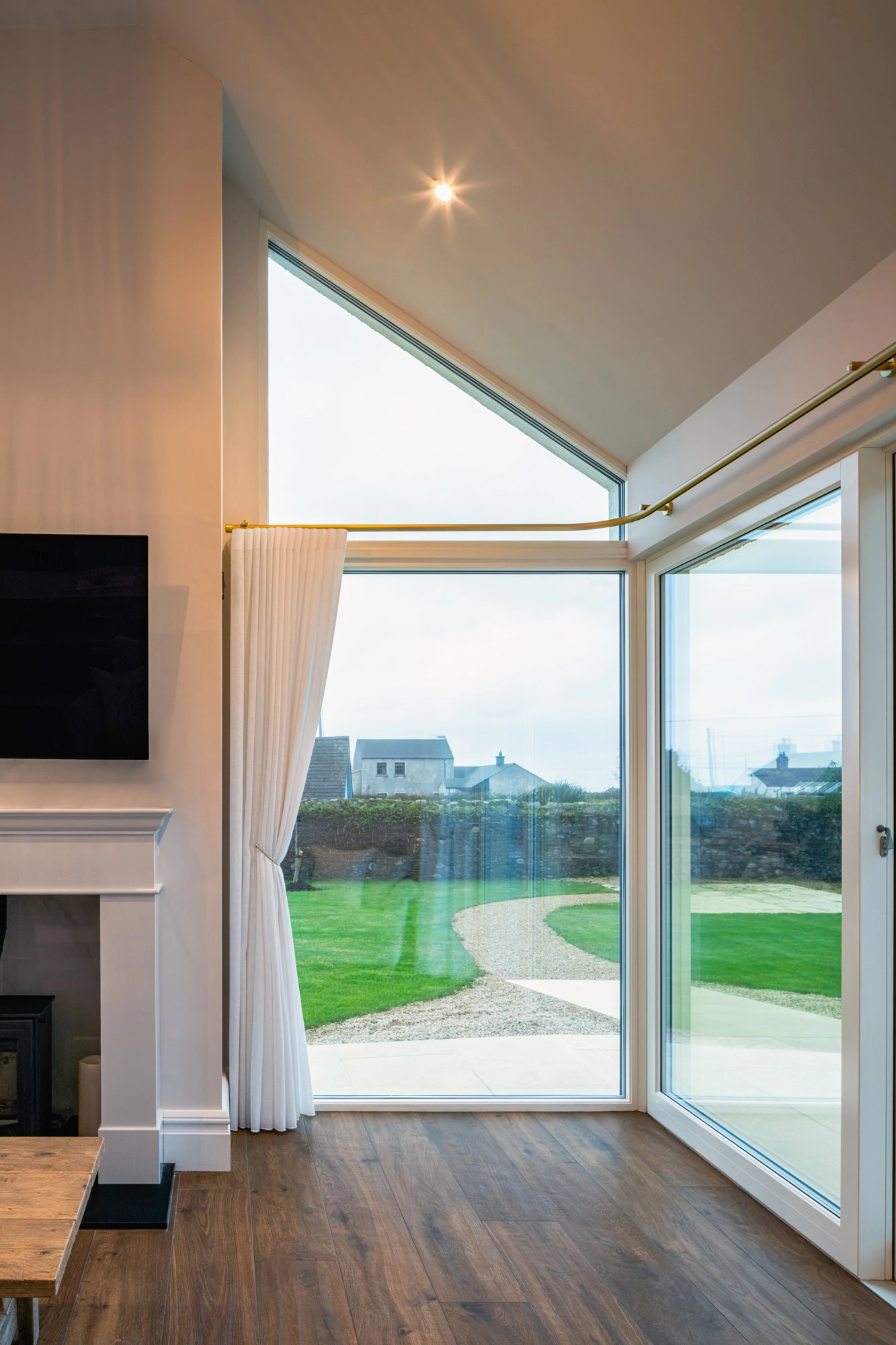A modern living room with a window with a white curtain.
