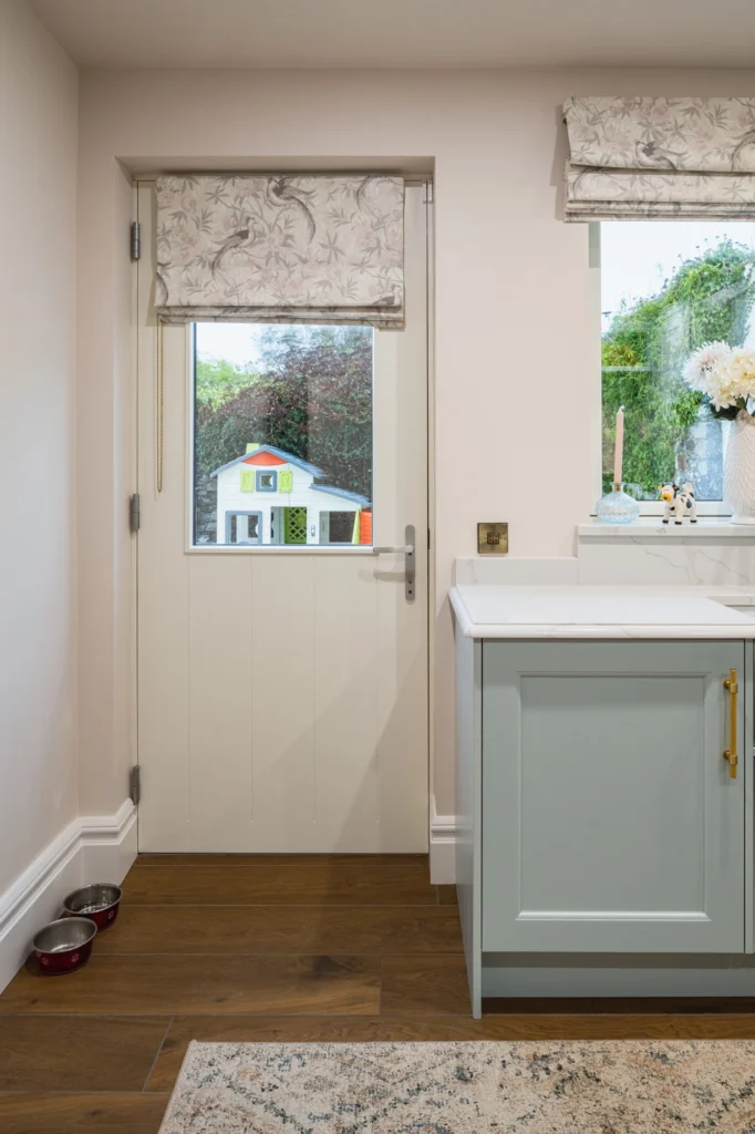 A white kitchen room with blinds rolled up.