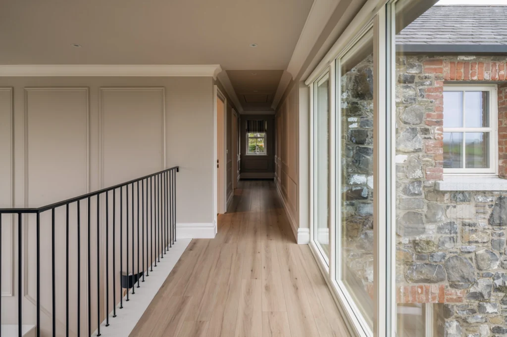 A long hallway with black railing on the left side.