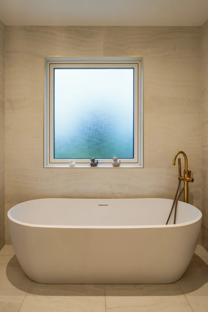 Modern bathroom with a bathtub and a golden faucet.