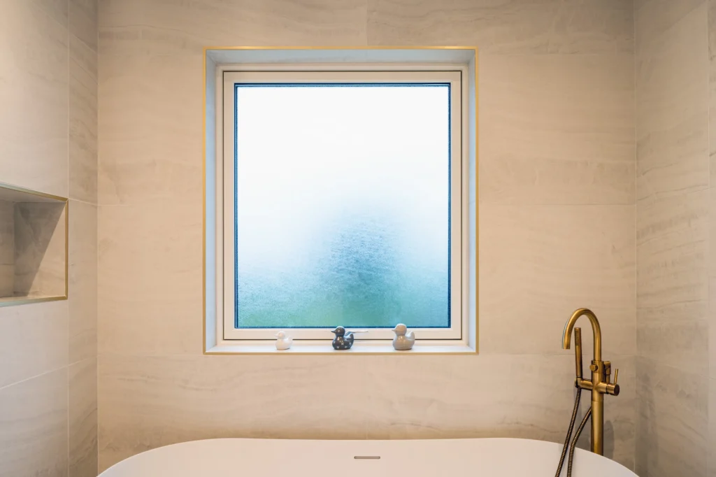 Modern bathroom with a bathtub and a golden faucet.
