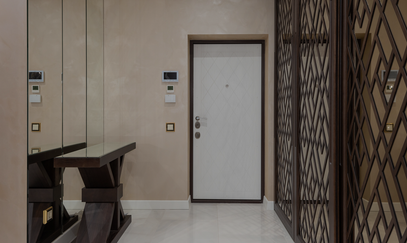 Elegant hallway featuring a white door, large mirrors, and decorative dark wood wardrobes.