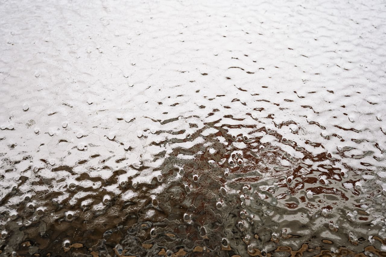 Textured frost and ice layer covering a glass surface.